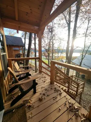 a porch of a cabin with benches and a view of the water at Sweet Tree Cabin with Grill Overlooking Tappan Lake in Ohio in Deersville