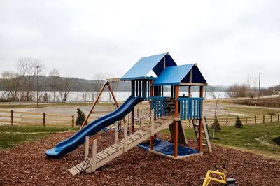 a playground with a slide in a park at Sweet Tree Cabin with Grill Overlooking Tappan Lake in Ohio in Deersville