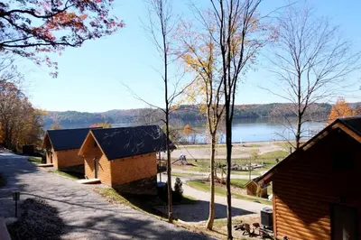 a couple of small wooden buildings next to a lake at Lovely Rural Cabin Nestled Among Nature by Tappan Lake in Ohio in Deersville