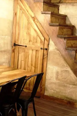 a wooden door with a wooden table and a chair at Renovated Cottage with Spa Surrounded by Beautiful Hiking Trails by Tappan Lake in Ohio in Deersville