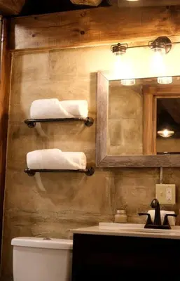 a bathroom with a sink and a mirror and towels at Renovated Cottage with Spa Surrounded by Beautiful Hiking Trails by Tappan Lake in Ohio in Deersville