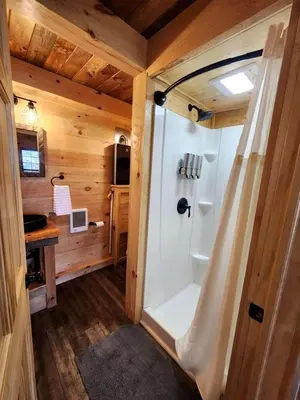 a bathroom with a shower in a log cabin at Lofted Cabin Wonderful for Outdoor Adventures near Tappan Lake in Ohio in Deersville