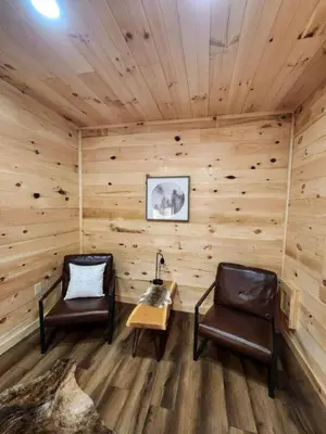 two chairs and a table in a room with wooden walls at Modern Spacious Cabin near Tappan Lake with Jacuzzi and Panoramic Views in Ohio in Deersville