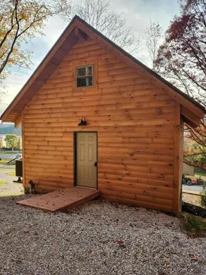 a large wooden building with a door on it at Modern Spacious Cabin near Tappan Lake with Jacuzzi and Panoramic Views in Ohio in Deersville