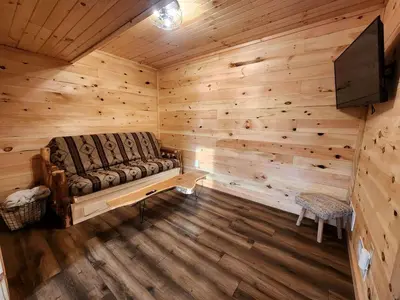 a room with a couch in a log cabin at Modern Spacious Cabin near Tappan Lake with Jacuzzi and Panoramic Views in Ohio in Deersville