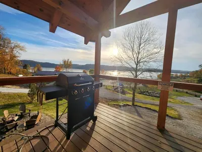 a grill on a deck with a view of the water at Luminous Cabin near Tappan Lake with Hot-Tub, BBQ and Deck in Ohio in Deersville