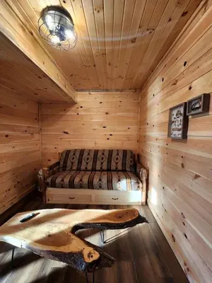 a bedroom with a bed in a log cabin at Luminous Cabin near Tappan Lake with Hot-Tub, BBQ and Deck in Ohio in Deersville