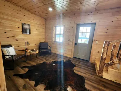 a room with a room with a log wall at Luminous Cabin near Tappan Lake with Hot-Tub, BBQ and Deck in Ohio in Deersville