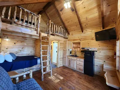 a log cabin with a bunk bed and a kitchen at Wooden Chic Cabin Fully Stocked near Tappan Lake in Ohio in Deersville