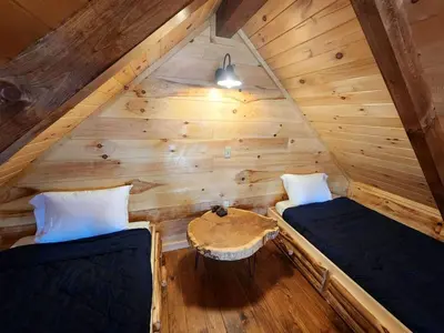 a room with two beds and a table in a cabin at Wooden Chic Cabin Fully Stocked near Tappan Lake in Ohio in Deersville