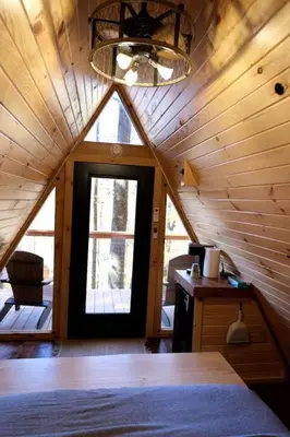 a room with a wooden ceiling with a door and a window at Cozy Tree Cabin with Wonderful Views from the Deck by Tappan Lake in Ohio in Deersville