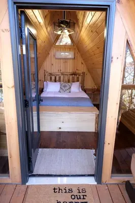 a tiny house with a bed inside of it at Cozy Tree Cabin with Wonderful Views from the Deck by Tappan Lake in Ohio in Deersville
