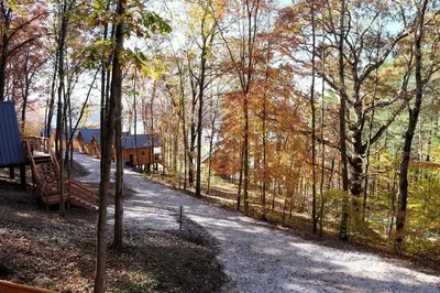 a dirt road with a playground in the woods at Cozy Tree Cabin with Wonderful Views from the Deck by Tappan Lake in Ohio in Deersville
