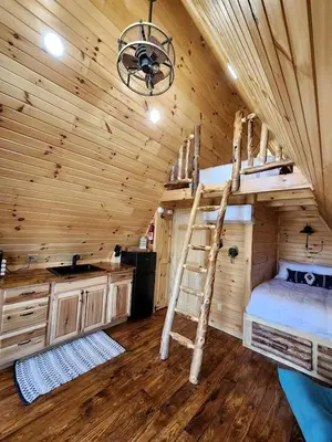 a bedroom with a bunk bed in a log cabin at Rustic Tree A-Frame with Original Design by Tappan Lake in Ohio in Deersville