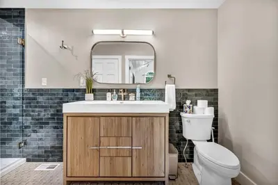 a bathroom with a sink and a toilet and a mirror at Cozy Secluded Cabin with Games and Hot-tub in Sarahsville, Ohio
