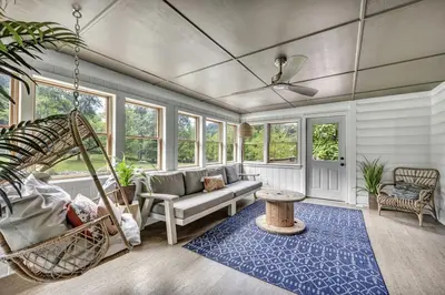 a living room with a couch and a swing at Cozy Secluded Cabin with Games and Hot-tub in Sarahsville, Ohio