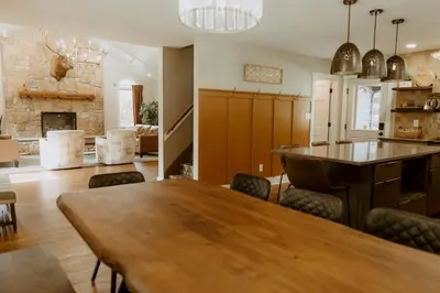 a living room with a table and a fireplace at 16 Guests | Ponds | Hot Tub | Game Room | Trails in Sarahsville