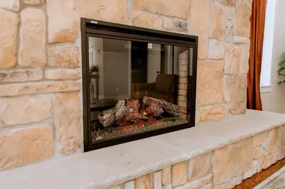 a stone fireplace with meat cooking in it at 16 Guests | Ponds | Hot Tub | Game Room | Trails in Sarahsville
