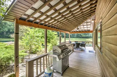 a screened in porch with a grill on a deck at Exquisite Cabin with Amazing Interior and Exterior in Sarahsville, Ohio