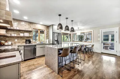 a large kitchen with a large island with bar stools at Exquisite Cabin with Amazing Interior and Exterior in Sarahsville, Ohio