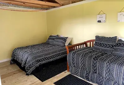 a room with two beds in a room at Charming Cabin Surrounded by Woods and Fields in Oberlin, Ohio in Oberlin