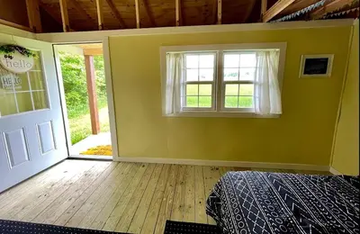 an empty room with a bed and a window at Charming Cabin Surrounded by Woods and Fields in Oberlin, Ohio in Oberlin