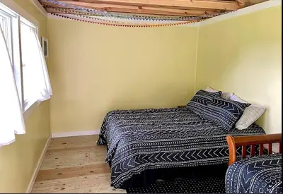 a bedroom with a bed and a window at Charming Cabin Surrounded by Woods and Fields in Oberlin, Ohio in Oberlin