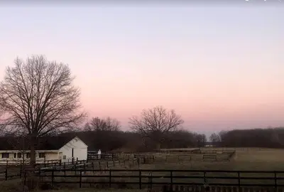 a farm with a fence and a barn and trees at Cozy Cabin Surrounded by Fields and Woods in Oberlin, Ohio in Oberlin