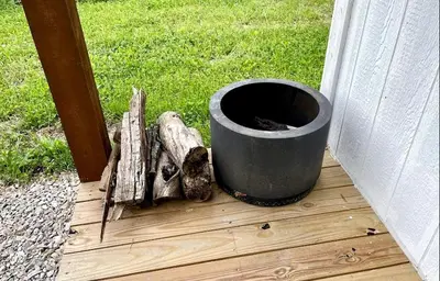 a bucket sitting on top of a wooden deck at Cozy Cabin Surrounded by Fields and Woods in Oberlin, Ohio in Oberlin