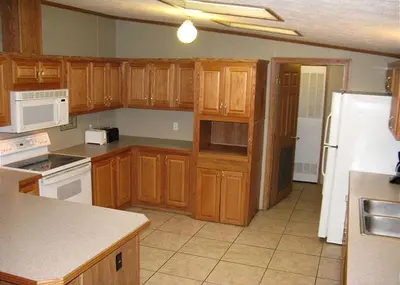 a kitchen with wooden cabinets and a white refrigerator at Spacious Vacation Cottage Rental near the Waterfront in Beautiful Put-in-Bay, Ohio in Put-in-Bay