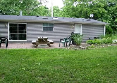 a house with a picnic table and chairs in the yard at Spacious Vacation Cottage Rental near the Waterfront in Beautiful Put-in-Bay, Ohio in Put-in-Bay