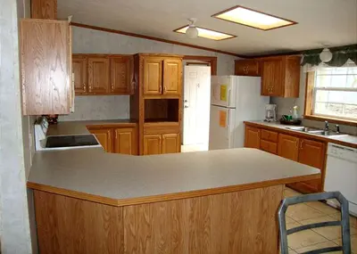 a kitchen with wooden cabinets and a white refrigerator at Spacious Vacation Cottage Rental near the Waterfront in Beautiful Put-in-Bay, Ohio in Put-in-Bay