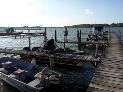 a group of people sitting at a dock with a boat at Enchanting Cottage Rental in Marblehead, Ohio in Marblehead