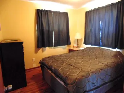 a bedroom with a bed and two windows at Secluded Cottage Rental in the Trees by Lake Erie, Ohio in Marblehead