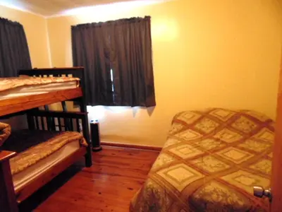 a bedroom with two bunk beds and a window at Secluded Cottage Rental in the Trees by Lake Erie, Ohio in Marblehead