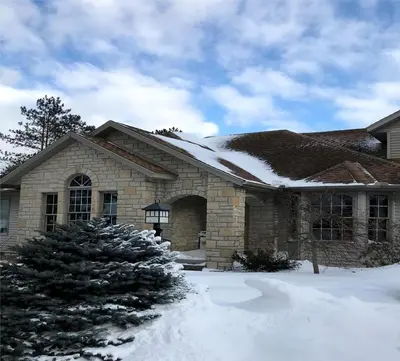 a house with snow on the roof at Enchanting Vacation Rental with a Private Fishing Stream in Sandusky, Ohio in Sandusky