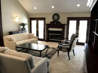 a living room with a couch and chairs and a fireplace at Enchanting Vacation Rental with a Private Fishing Stream in Sandusky, Ohio in Sandusky