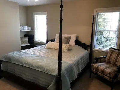 a bedroom with a bed and a chair and windows at Enchanting Vacation Rental with a Private Fishing Stream in Sandusky, Ohio in Sandusky