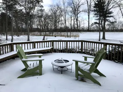 two chairs and a table in the snow at Enchanting Vacation Rental with a Private Fishing Stream in Sandusky, Ohio in Sandusky