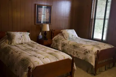 a bedroom with two beds and a table with a lamp at Inviting Suite Rental in a Charming Farmhouse in Sandusky, Ohio in Sandusky