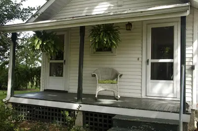 a porch of a house with a chair on it at Secluded 1800's Farmhouse Rental Minutes from Cedar Point, Ohio in Sandusky