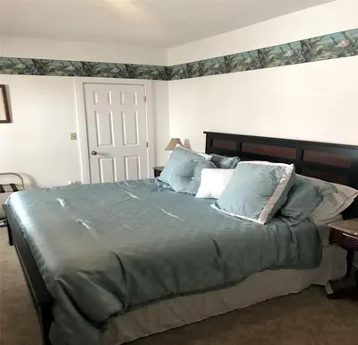 a bedroom with a large bed with blue pillows at Secluded 1800's Farmhouse Rental Minutes from Cedar Point, Ohio in Sandusky