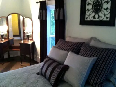 a bedroom with a bed with two pillows and a window at 1800s Farmhouse Cottage Rental on a 230 Acre Farm in Muskingum County, Ohio in Frazeysburg