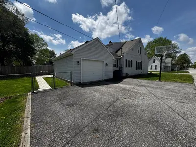 a white house with a garage on a street at Hawks Nest in Marion