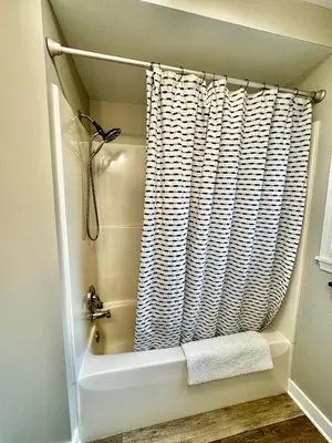 a bathroom with a bath tub and a shower curtain at Hawks Nest in Marion