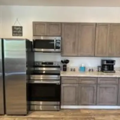 a kitchen with stainless steel appliances and wooden cabinets at The Murphy in Sutton