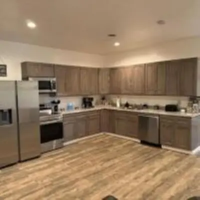 a kitchen with wooden cabinets and stainless steel appliances at The Murphy in Sutton