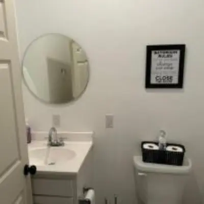 a white bathroom with a sink and a mirror at The Murphy in Sutton