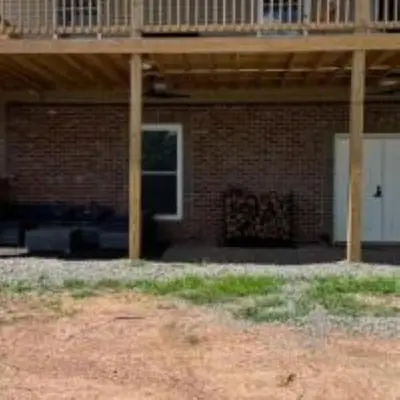 a porch of a brick house with a deck at The Murphy in Sutton