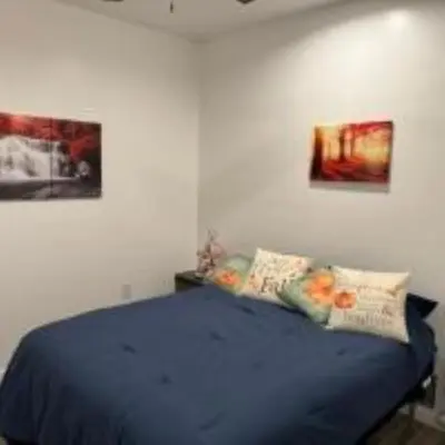 a bedroom with a blue bed with two pictures on the wall at The Murphy in Sutton